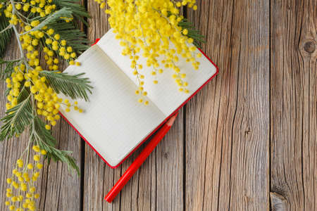 rural wooden table with notebook and love message, yellow spring flowersの写真素材