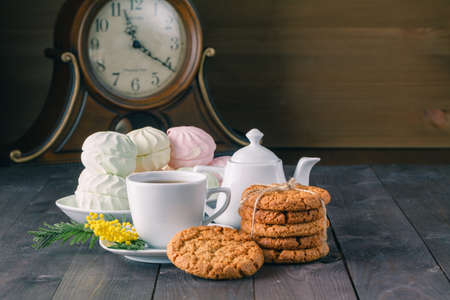 clock and breakfast on dark wooden tableの写真素材