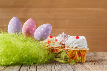 eastern egg on wood background with cupcakesの写真素材