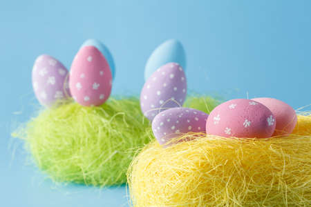 Springtime nest with colorful Easter Eggs against blue background