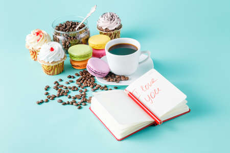 Morning breakfast for her with message i love you. French macaroon and coffee, notebook with messageの写真素材