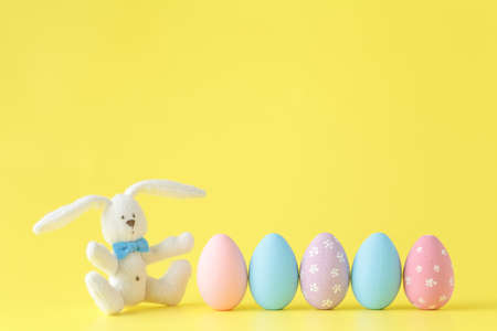 Easter eggs painted in pastel colors on yellow paper background. Easter conceptの写真素材