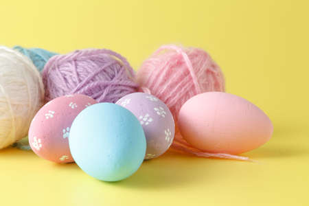 Pastel and colored Easter eggs and wool clew
