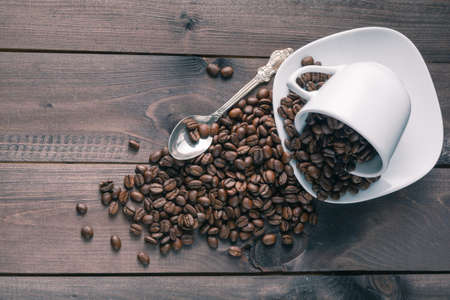 roasted coffee bean in a cup on rustic wood backgroundの写真素材