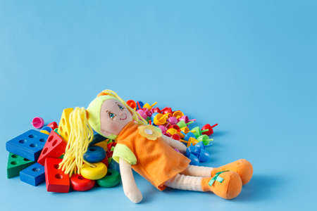 Mix of wooden toy blocks with doll on blue backgroundの写真素材