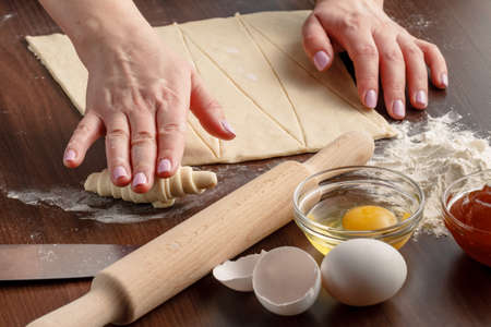 Woman is making croissant in the kitchenの写真素材