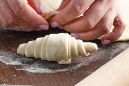 Woman is making croissant in the kitchenの写真素材