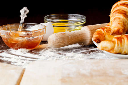 Ingredients for baking croissants - flour, wooden spoon, rolling pin, eggs, egg yolksの写真素材