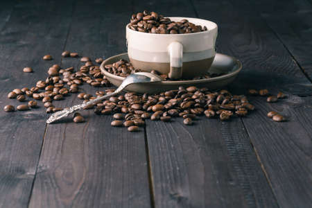 Breakfast with coffee beans and fresh croissant on wooden table