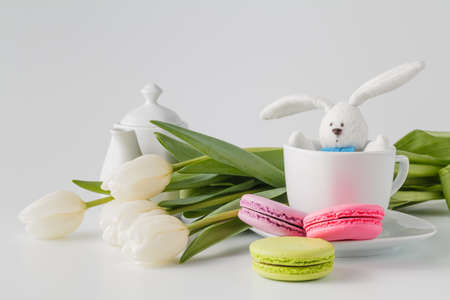 cup of tea with tulips on a white wooden background