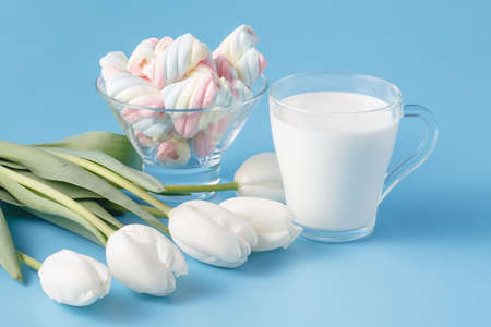 glass of fresh milk and tulips with marshmallowの写真素材