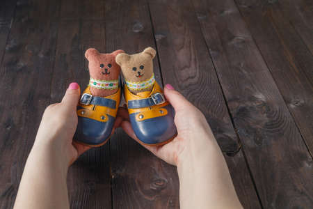 Future parents holding a pair of little shoes