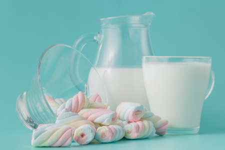 Heap of colored twisted marshmallow with glass of milkの写真素材