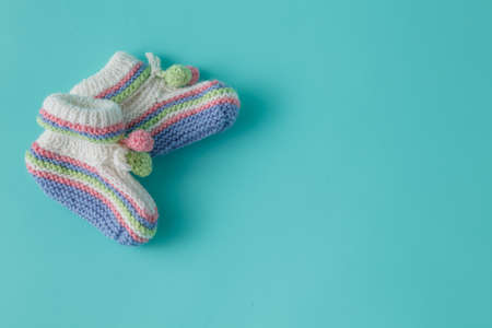 Newborn announcement template. Handmade knitted booties on plain backgroundの写真素材