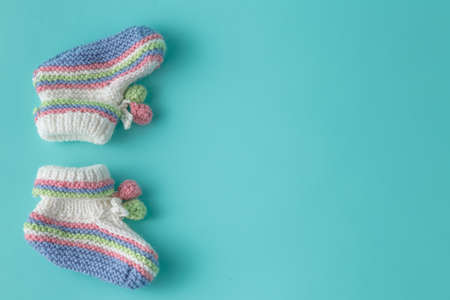 Newborn announcement template. Handmade knitted booties on plain backgroundの写真素材