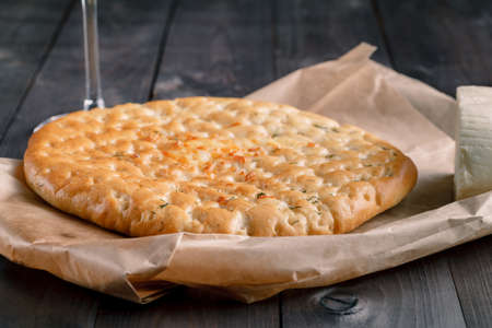 Focaccia bread on paper and dark wood tableの写真素材