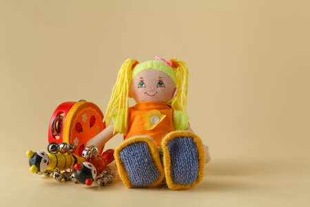 Musical instruments and doll on beige backgroundの写真素材