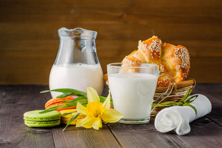 Milk with pastry and spring yellow flower on tableの写真素材