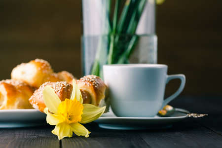 Spring breakfast with pastry and spring flowers in glassの写真素材