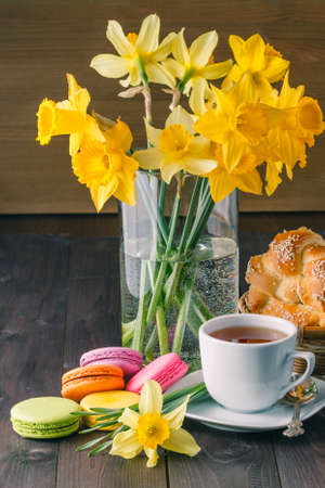 Relax breakfast with macaroons and narcissus spring flower on tableの写真素材
