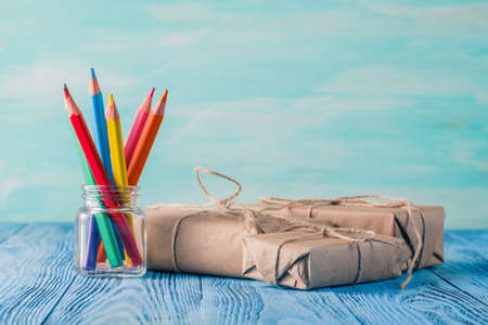 Few gift boxes and colour pencils in jar on tableの写真素材