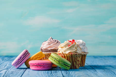 Sweet colorful macaroon with cupcake on blue tableの写真素材