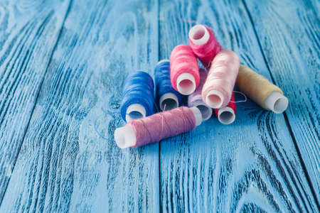 Colored sewing threads on a old work tableの写真素材