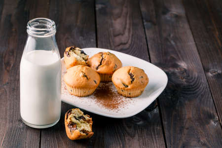 Breakfast with pastry and milk in bottle on tableの写真素材