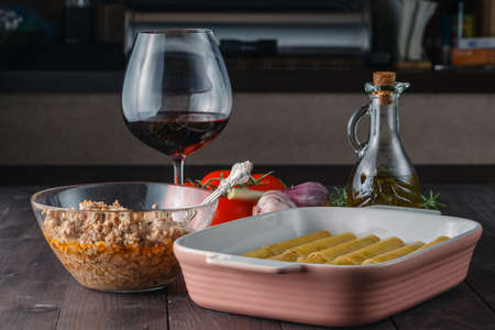 Woman making cannelloni or lasagne on kitchenの写真素材