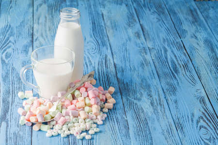 Pastel colored candy in a pile on a blue surfaceの写真素材