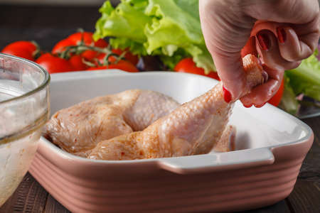 raw chicken legs in marinade ingredients on the kitchen boardの写真素材