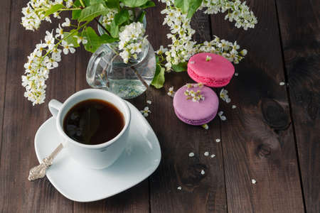 Delicious macaroon with beautiful flowers on wooden backgroundの写真素材
