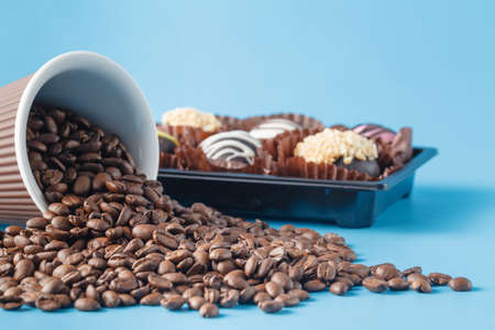 Cup with coffee beans on blue