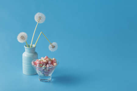 Colored twisted marshmallow on background with dandelionsの写真素材