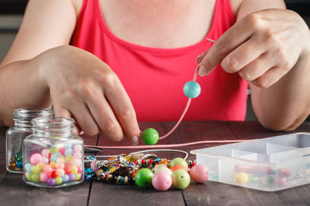 Woman making necklace from colorful beadsの写真素材