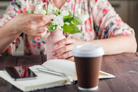 Woman hold white flowers on the rustic background.の写真素材