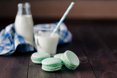 Homemade macaroons with glass of milk on tableの写真素材