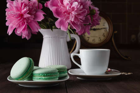 Bouquet of peonies blooms in vase with macaroonsの写真素材