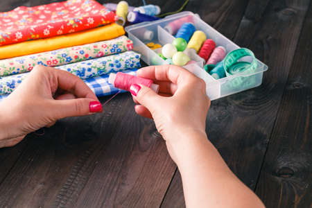 Senior women sews by hand