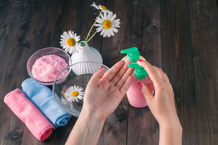 Female hands using dispenser with liquid soapの写真素材