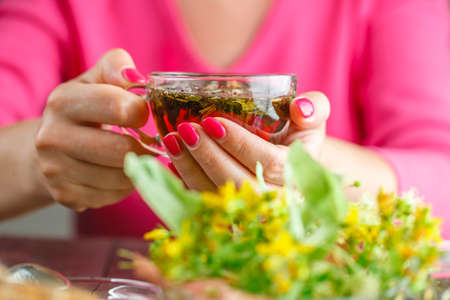 Closeup of female holding a mug. Selective focus on hands and fingersの写真素材