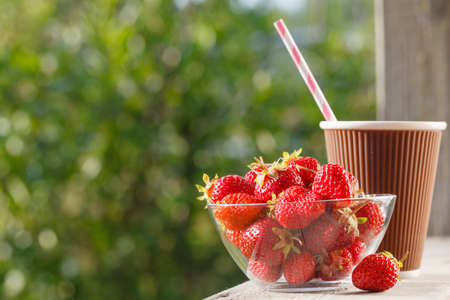 Strawberries in a bowl, natural background, outsideの写真素材