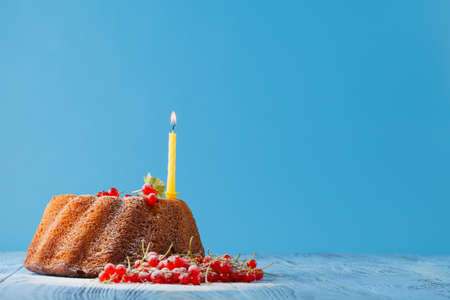 Kid birthday sweet cake with one candle on blueの写真素材