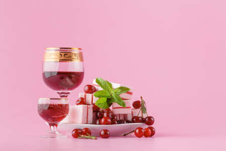Cherry liqueur and sweets on plain pink backhroundの写真素材