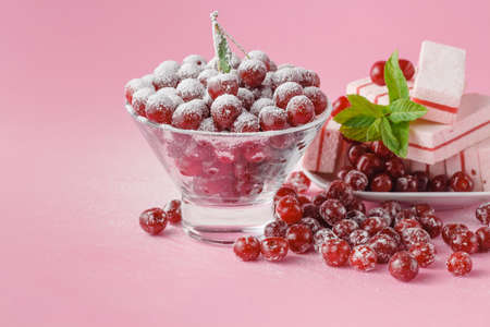 Milk glass and dusted powdered sugar with cherries and mintの写真素材