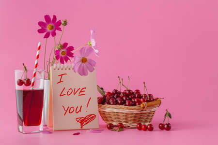 Cherry baskets and juice on pink background with message i love youの写真素材