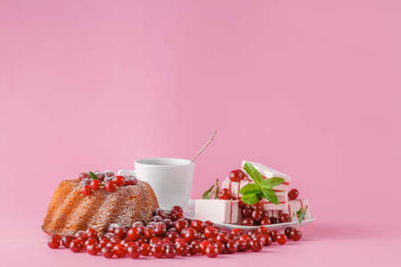 celebratory cake with cherries and sugar powder on pinkの写真素材