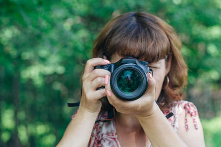 Pretty woman is a professional photographer with dslr cameraの写真素材