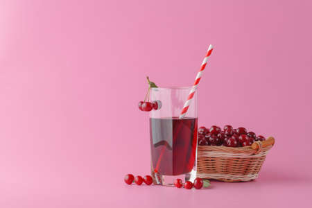Glass of fresh juice with cherries on bright backgroundの写真素材
