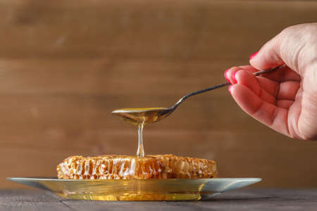 honey dipping on honeycombの写真素材